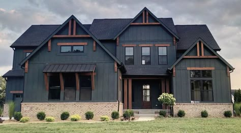 Dark Home Exterior With White Windows, Dark Grey House With Wood Accents, Dark Exterior Homes, Black Houses With Wood Accents, Black House With Wood Accents, Black Barndominium Exterior, Black Farmhouse Exterior, Dark Modern Farmhouse Exterior, Black Houses