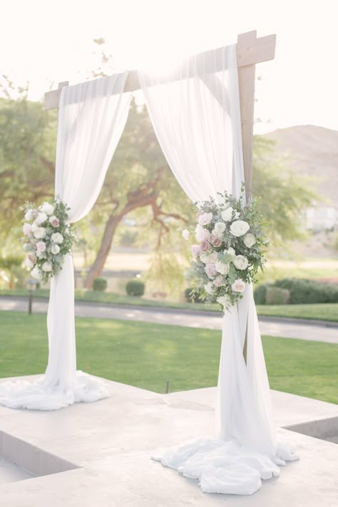 Wooden square wedding arch with white draping and two large spring flower pieces with blush, ivory, and lavender flowers.  Large tree and greenery background.  #lasvegasweddingvenue #woodarch #microweddingslasvegas July Wedding Colors, Flower Arch Wedding, Wood Wedding Arches, Bridesmaid Dresses White, Greenery Bouquets, Wooden Wedding Arches, White Wedding Arch, Most Beautiful Flower, Draping Wedding