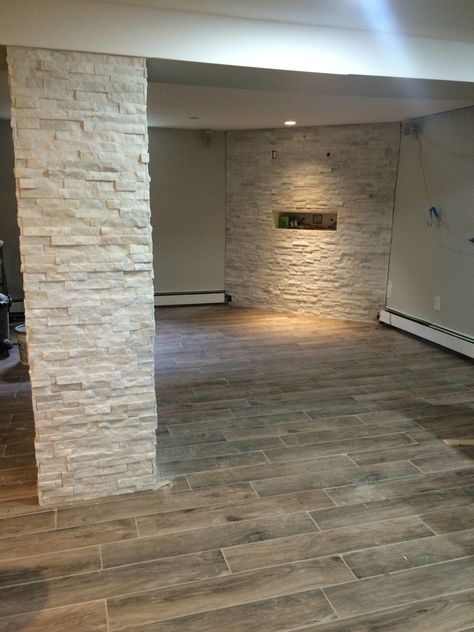 White Arctic stone column, and TV wall. Woodland Oak porcelain floors. Stone Columns Interior, Internal Stone Wall Ideas, Columns In Living Room Open Floor, Stone Accent Wall Basement, Interior Stone Columns, Half Stone Half Wood Pillars, Faux Stone Half Wall Interior, Columns In Living Room, Wall Tiles Living Room