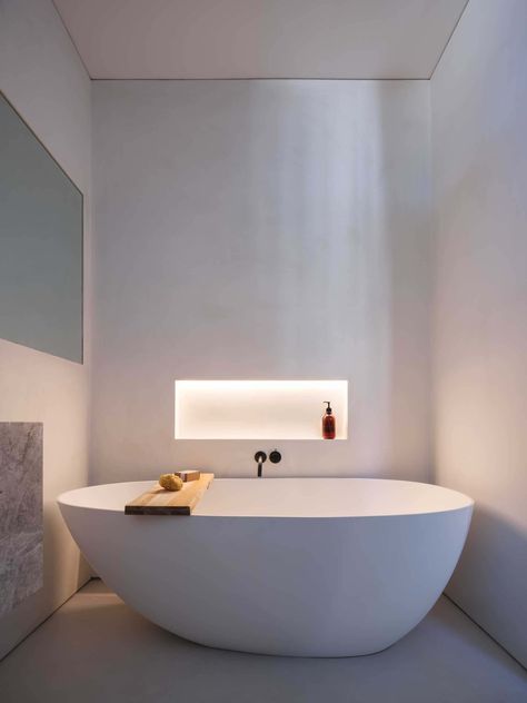 This modern bathroom has a shelving niche by the bathtub. Hidden LED lighting has been included, which when turned on, creates a soft glow and adds to the calm atmosphere of the bathroom. Bathtub Niche Ideas, Niche Bathtub, Bath Tub Lighting, Bathtub Niche, Niche In Wall, Bathtub Lighting, Magical Treehouse, Alcove Lighting, Bathtubs For Small Bathrooms