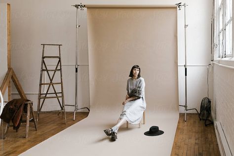 behind the scenes of model sitting in front of backdrop seamless paper in photo studio with props around by Nicole Mason for Stocksy United Photography Paper Backdrops, Seamless Backdrop Photography, Seamless Backdrop Photoshoot, Paper Backdrop Photoshoot, Paper Backdrop Ideas, Paper Backdrop Photography, Seamless Paper Photography, Photoshoot Diy, Backdrop Photoshoot