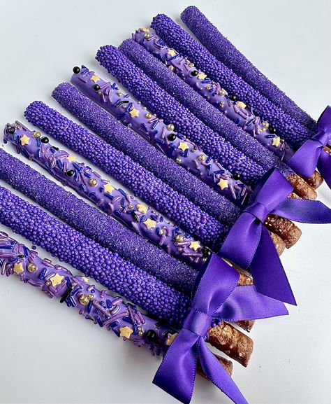 This listing is for 12 pretty purple pretzels. Each fresh pretzel rod is dipped in creamy purple chocolate and decorated with 3 different sprinkles: purple sugar, purple nonpareils and purple jimmies with gold stars. A perfect addition to a dessert table, a birthday party or shower. So beautiful that all the guests will want one.  Each favor will arrive to you individually wrapped in a clear cellophane sleeve and tied with color coordinating ribbons.  Delightful Chocolates cannot be held responsible for melted chocolate once the package has left our facility. We take great pride in insulating our boxes and packaging with ice sheets if needed PLEASE PURCHASE ICE SHEETS IF YOU LIVE IN A WARM CLIMATE. WE WILL NOT SHIP IF YOU ARE IN TEMPERATURES OF 65 DEGREES OR ABOVE  These confections were c Purple Birthday Party Snacks, Purple Themed Snack Board, Purple Party Favors Ideas, All Purple Birthday Party, Purple Themed Food Board, Purple And Blue Party Decorations, Purple Chocolate Covered Pretzels, Witchy Snacks, Green And Purple Party