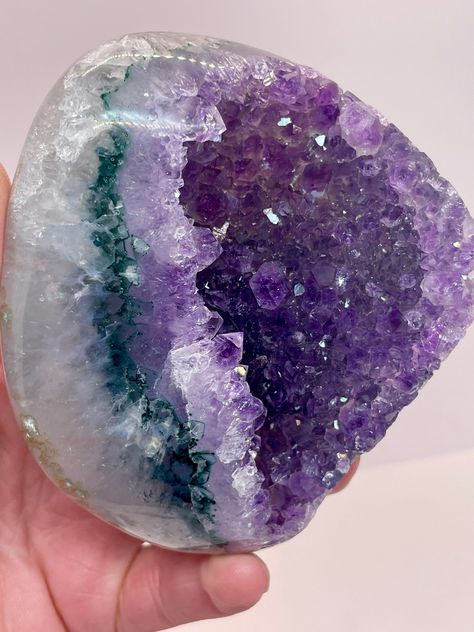 A gorgeous, solar eyed Uruguay Amethyst that's raw in the center and polished on the sides! An amazing, top quality color Amethyst with insane shine and a green/teal layer between the rainbow shine and the Quartz base colors! In this specimen you get a cross of raw and polished with icy purple rainbow colors and free standing crystals inside the mouth of the crystal. There is a ton of inclusions and deposits of minerals inside the Quartz base!  Amethyst clusters from Uruguay are known to be the top-pest of quality! Please let me know if you have any questions. All sales final, no returns or refunds. Follow my lapidary journey @mercsminerals on IG and TikTok! Size: 97x82mm and 427 grams ( almost a pound of beauty!) Gazing Globe, Rainbow Aura Quartz, Purple Rainbow, Rock City, Purple Quartz, Crystal Therapy, Crystal Geode, Crystal Magic, Amethyst Cluster