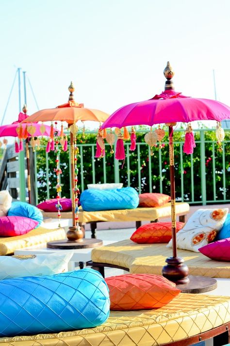 Lounge seating with lots of plush pillows is perfect for a mehndi party. If your event is outdoors, add a burst of color with umbrellas that match the decor. | via Suhaag Garden Mehndi Party, Mehndi Night, Moroccan Theme, Garden Wedding Reception, Bollywood Party, Marriage Decoration, Mehndi Decor, Outdoor Wedding Reception, Garden Party Wedding