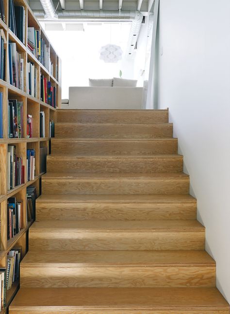 In Toronto a studio doubles as a live-work space, thanks in part to a custom bookcase that provides easy-access storage while also separating the studio space below from the stairs and bedroom above. Photo by Matthew Williams.  Photo by: Matthew WilliamsCourtesy of: matthew williams Wide Stairs, Live Work Studio, Live Work Space, Plywood Interior, Work Studio, Stairway Design, Serene Bedroom, Wood Stairs, Built In Bookcase