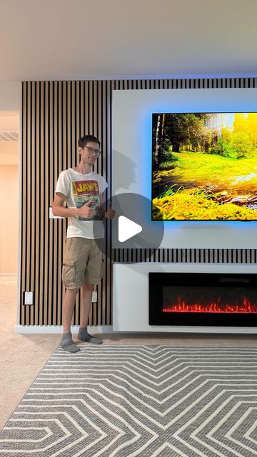 Modern Wall Cal on Instagram: "Watch the magic unfold as we transform your living space with a stunning fireplace and a sleek floating panel. Elevate your home decor game and create a cozy sanctuary that radiates style and warmth. Get ready for a total makeover that will leave you in awe! 🔥✨  This installation includes: ✅Floating panel  96 by 60 inches with backlight around  ✅floating fireplace unit 96 inches with electric fireplace  ✅Wooden slats on wall Natural Oak" Slat Wall Electric Fireplace, Wooden Slats On Wall, Slats On Wall, Electric Fireplace Built In, Linear Fireplace With Tv Above Modern, Wood Slat Fireplace Wall, Built In Electric Fireplace Ideas, Wall Units With Fireplace, Floating Fireplace