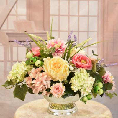 Our designers choose a soothing combination of flowers and hues in soft pinks and greens for this design. Set this beautiful silk floral centerpiece just about anywhere to add color and elegance to your home or office. Created with peonies, ranunculus, soft green and pink hydrangeas, mini roses, berries and foliage. Set in a silver metal low pedestal bowl. Perfect for a dining table, coffee table, dresser, an event or party. | Primrue Faux Silk Arrangement in Vase in Pink | 15" H X 20" W X 14" D Floral Centerpieces For Dining Table, Summer Floral Centerpieces, Pink Hydrangea Centerpiece, Pink Hydrangea Centerpieces, Spring Flower Arrangements Centerpieces, Ranunculus Centerpiece, Silk Floral Centerpiece, Seasonal Plants, Pink Flower Arrangements