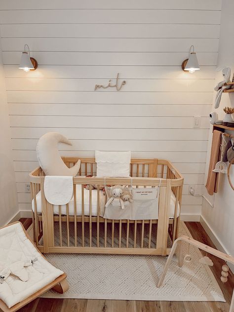 Are you as drawn to the natural wood and shiplap combination in this nursery as I am? The use of wood adds warmth and character to the space, while the shiplap gives it a rustic touch. The wooden name sign bring a touch of nature and life to the room, making it feel like an oasis for the little one. The overall aesthetic is calming and inviting, and I can't wait to see how this space will continue to evolve as the baby grows. Nursery Design by @mabellaflete White And Wooden Nursery, Wood Accent Nursery, Nursery Ideas Shiplap, Shiplap Nursery Wall Gender Neutral, Nursery Ideas Natural Wood, Shiplap In Nursery, Shiplap Wall In Nursery, White Shiplap Nursery, Nursery With Natural Wood Crib