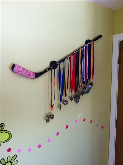 DIY idea: A hockey stick with metal hooks as medal display. Hockey Stick Medal Hanger, Hockey Metal Display, Hockey Medal Display Ideas, Medal Display Ideas Diy, Diy Medal Display, Hockey Diy Crafts, Dance Trophies, Diy Medal, Hockey Stick Crafts