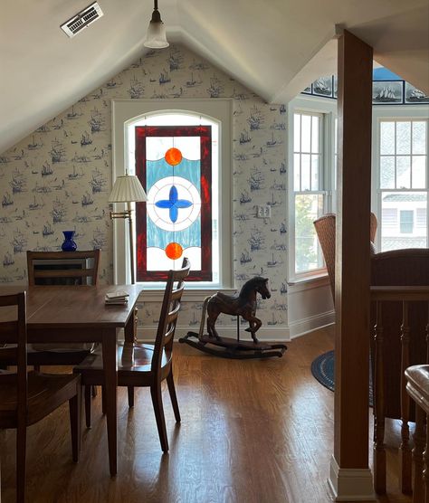 room in victorian beach house with a stained glass window, vintage furniture, and ship patterned wallpaper Victorian Beach Cottage, Connecticut House Aesthetic, Old Coastal Homes, British Seaside House, Victorian Coastal Home, New England Beach House Interior, Aesthetic Victorian House, New England Cottage Interiors, Old Beach House Aesthetic