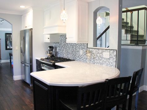 The curved peninsula in this transitional kitchen creates the perfect eat-in bar. The white and black cabinets and gray backsplash create an elegant feel in the space. The rich wood floors also allow this kitchen to feel warm and inviting. Peninsula Kitchen Ideas, White Traditional Kitchen, White Transitional Kitchen, Curved Kitchen Island, Peninsula Kitchen, Curved Kitchen, Kitchen Peninsula, Grey Backsplash, Storage Inspiration