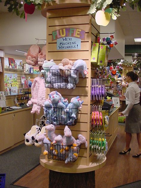 Slatwall on columns that cannot be removed since they support the structure of your space. Toys Shop Design, Kids Store Display, Toy Shop Display, Toy Store Design, Stuffed Animal Displays, Gift Shop Interiors, Gift Shop Displays, Bookstore Design, Dog Grooming Shop