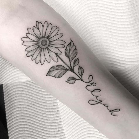 Forearm tattoo traditional black and grey stipple shading daisy with stem forming cursive script ‘Elijah Daisy Tattoo For Mom, Forearm Daisy Tattoo Women, Daisy Tattoo For Daughter, Daisy Flower With Name Tattoo, Tattoo Flower With Words, Flower With Cursive Stem Tattoo, Top Forearm Tattoo Women Simple, Daisy Name Tattoo Designs, Margarita Name Tattoo