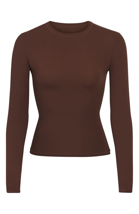 This crewneck T-shirt with a buttery-soft feel that perfectly hugs your curves can be worn alone or layered under other favorite pieces. It's part of Kim Kardashian's much-loved SKIMS line. 20 1/2" length (size Medium) Crewneck Long sleeves 76% polyamide, 24% elastane Machine wash, tumble dry Imported Body Stretching, Square Neck Bodysuit, Layered T Shirt, Crew Neck Tshirt, Leather Corset, Sleeveless Bodysuit, Lace Bodysuit, Cut Shirts, Long Sleeve Bodysuit