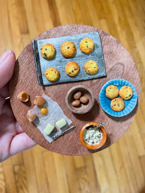 Miniature chocolate chip cookies on a silver baking pan, with cookies on a plate, a bowl with dough, eggs, eggshells and butter laid out nearby Polymer Clay Food, Miniature Polymer Clay, Baking Clay, Clay Food, Chocolate Chip Cookie, Wooden Board, Clay Creations, Soft Pastel, Chocolate Chip Cookies