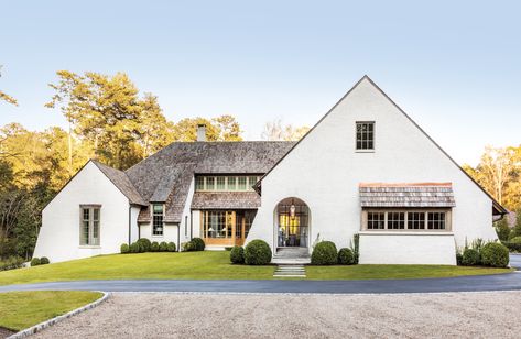 A Western red cedar shake roof and façade of lime-washed Wood Mould brick bring storybook appeal to the approach of this Atlanta home by architect Peter Block, who was partly influenced by the work of Belgian architect Bernard De Clerck, along with English Arts & Crafts icons C.F.A Voysey and Sir Edwin Lutyens. The feature windows were custom made of European white oak by Germany’s Bildau & Bussmann. Cedar Shake Roof, Shake Roof, Atlanta Homes, Luxe Interiors, Farmhouse Art, Home Tours, Interiors Design, Residential Design, 인테리어 디자인