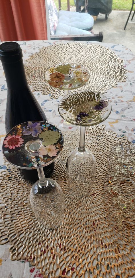 Wine glasses with floral accents on the bottom of the glass Resin Wine Glasses, Wine Glass Diy, Flowers Wine, Glass Diy, Wine Glass Charms, Pressed Flower, Uv Resin, Hand Designs, Pressed Flowers