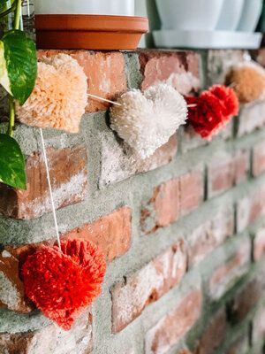 Valentines Pom Pom Garland, Valentine's Garland Diy, Fireplace Valentine Decor, Diy Valentines Day Garland, Yarn Heart Garland, Valentines Home Decor Diy, February Mantle Decor, Valentine’s Day Mantle Decor, Simple Valentines Decor Diy