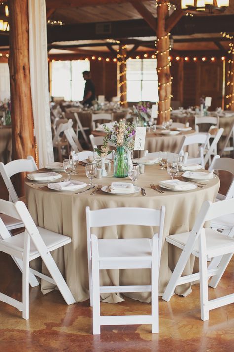 Natural linens on round tables with white resin chairs. White Chairs Wedding, Barn Wedding Centerpieces, Round Wedding Tables, White Folding Chairs, Tan Wedding, Candle Wedding Centerpieces, Wedding Table Linens, Wedding Tablecloths, Beige Wedding