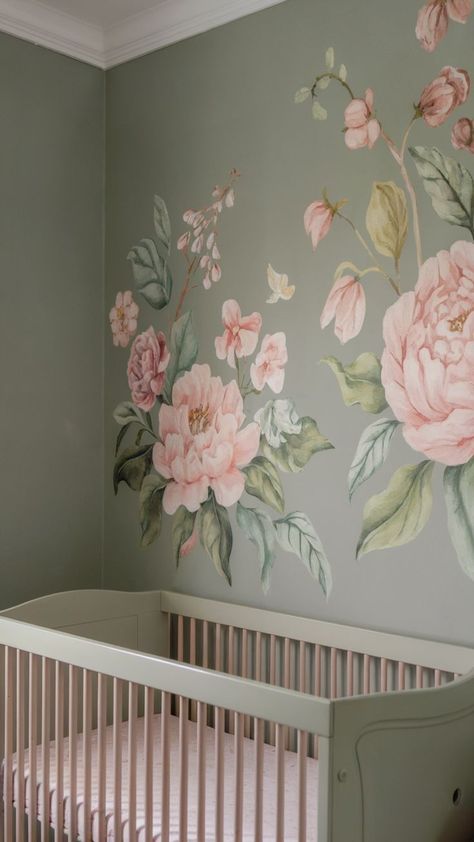 A floral-themed baby girl nursery with a sage green wall adorned with a hand-painted mural of pink flowers and lush greenery. The space features a soft green crib and pastel pink bedding, creating a peaceful and elegant atmosphere. Green Nursery Girl, Romantic Nursery, Baby Girl Nursery Ideas, Girl Nursery Ideas, Nursery Inspiration Girl, Floral Mural, Sage Green Wall, Sage Green Walls, Green Nursery