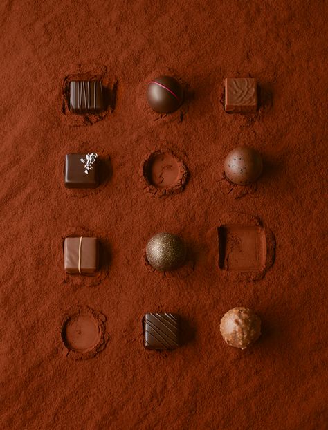 Luxury chocolates on a red cocoa powder background. Photography Chocolate, Chocolate Photography Ideas, Chocolate Photoshoot Ideas, Chocolate Background, Chocolate Photoshoot, Christmas Chocolate Photography, Chocolate Aesthetic Photography, Chocolate Bar Photography Ideas, Chocolate Photography