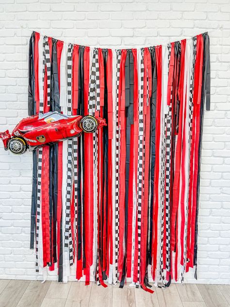 Add a touch of speed and style to your next event with our Race Car Fringe Backdrop. This eye-catching backdrop features a bold race car design in vibrant red, white, black, and checkerboard patterns. Perfect for car enthusiasts or anyone looking to inject some adrenaline into their celebration. Made from durable materials, this backdrop is available in various sizes to suit your venue's dimensions. The playful fringe detail adds an extra element of fun and movement to your event décor. Whether you're hosting a birthday party or a racing-themed gathering, our Race Car Fringe Backdrop is sure to rev up the excitement. Colors: Red, Black, White and Checker fridge.  Three sizes to choose from:  backdrop is approximately 7' in height and 4', 5', 6', 7' or 8' wide with extra rope on each side. Car Birthday Backdrop, Race Track Birthday, Dirt Track Birthday Party, Race To One Birthday, Race Car Party Backdrop, 4th Birthday Race Car Theme, Race Car Themed 3rd Birthday Party, Racing 3rd Birthday, Checkered Party Decorations