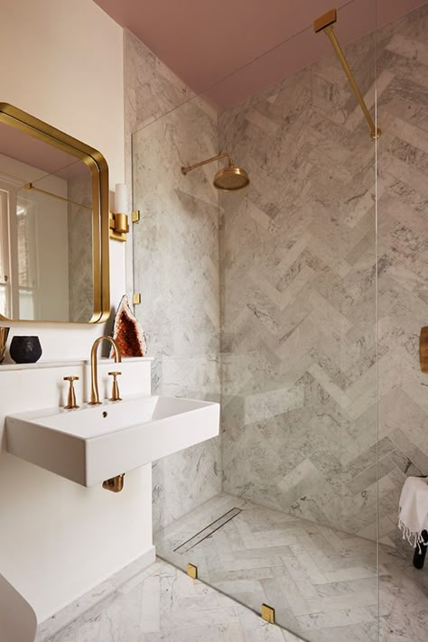 There's something super flattering about painted ceilings - why not give that fifth wall a little love?🌸This pink ceiling matched with these brass assets and marble-effect herringbone tiles creates a modern, minimalist bathroom design that we love!  📸: Victoria Tunstall Herringbone Tile Bathroom, Chevron Flooring, Appartement New York, Chevron Bathroom, Mandarin Stone, Minimalist Bathroom Design, Loft Bathroom, Perfect Bathroom, Small Bathroom Makeover