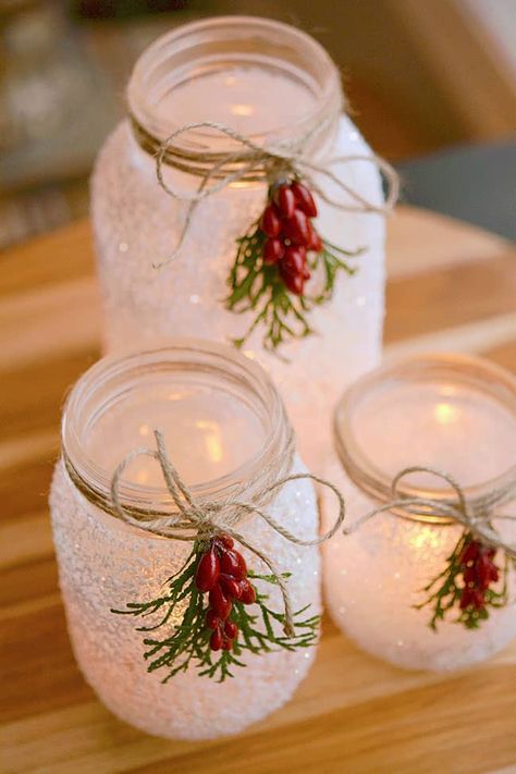 These DIY snowy mason jars made with glitter and epsom salt are SO PRETTY and they're really easy to make! A perfect Christmas craft that you can display all winter long. These mason jar luminaries are a great holiday project - and they only take 15 minutes to make! Winter Wonderland Mason Jars, Christmas Craft With Mason Jars, Lighted Mason Jars Christmas, Snowflake Mason Jar Centerpieces, Christmas Crafts Glass Jar, Mason Jar Luminaries Christmas, Easy Diy Christmas Candles, Snow Mason Jars, Glass Votive Crafts Diy Projects