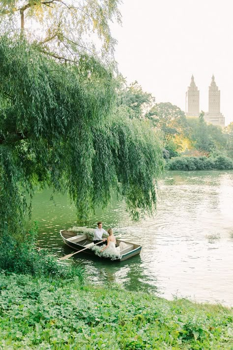 Bride and groom in a boat for a Central Park boat proposal, styled by destination wedding planner Britt Warnick Designs. The boat has a baby's breath boat floral installation, and the boat is overlooking central park in New York City in the summer. Central Park Boathouse, Boat Elopement Ideas, Proposals In Nature, Bayou Engagement Photos, Central Park Lake, Nyc Proposal Ideas, Bayou Photoshoot, Central Park Elopement, Central Park Wedding Photos