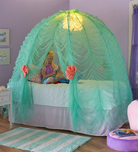 The Light-Up Under-the-Sea Bed Tent offers a generous space for imaginative play and features gentle waves of aqua fabric accented by the glittering LED sea urchin light and pops of color from the coral shells. Tent “floor” slips over a twin-sized mattress to create a cove any mermaid would be proud to call her own. UL connection included. Imported. Sea Life Bedroom, Sea Theme Bedrooms, Underwater Bedroom, Sea Bedrooms, Mermaid Wall Decals, Mermaid Bedding, Mermaid Bedroom, Theme Beds, Mermaid Room