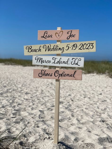 Gold and coral beach wedding directional sign. Could be a personalized gift for newlywed with bride and groom names, destination wedding place, shoes optional and wedding date. custom writing by request.   The sign is made of high-quality wood, hand-painted with love and care in the Sunshine State with a rustic finish. You can choose any colors and your favorite destinations to write on your custom sign. The sign comes pre-drilled for easy and fast assembly, and a self-stand option is available Boho Wedding Beach Decoration, Pink Wedding Theme Beach, August Beach Wedding, Wedding Aisle Decorations Beach, Welcome Sign For Beach Wedding, Diy Beach Wedding Decor, Simple Beach Wedding Ideas On A Budget, Beach Weddings On A Budget, Beach Wedding Activities