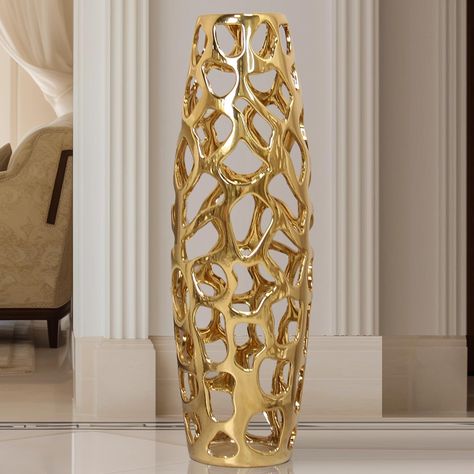 PRICES MAY VARY. Lustrous Golden Ceramic Vase: This exquisite ceramic vase features a hollow glossy finish, capturing the essence of sophistication. Crafted meticulously from porcelain, it showcases a shimmering golden hue that adds a touch of opulence to any space. Handcrafted Hollow Pattern: The ceramic vase boasts a meticulously handcrafted hollow pattern, displaying intricate craftsmanship. Each detail reflects artistic finesse, making it a fabulous piece that blends classic elegance with co Tall Vases For Fireplace, Tall Modern Vases, Large Vase Filled With Bauble’s, Vase Extra Large Fillers, Painting A Large Glass Vase, Gold Vase Greenery, Metallic Gold Vase, Grand Vase Pampas, Oversized Floor Vases Paint