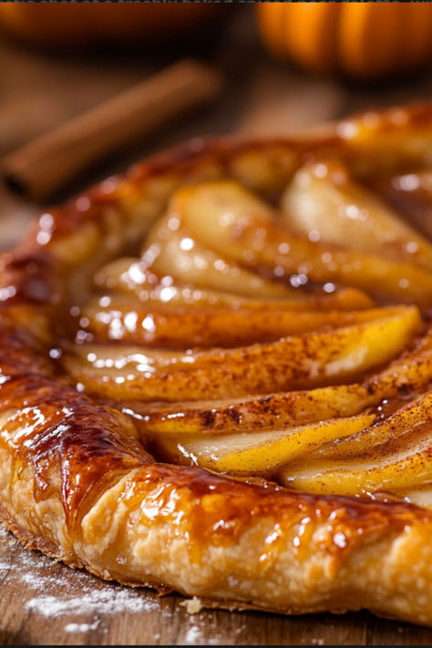 Golden, flaky pear galette topped with cinnamon and baked to perfection, evoking a warm and rustic fall baking vibe.