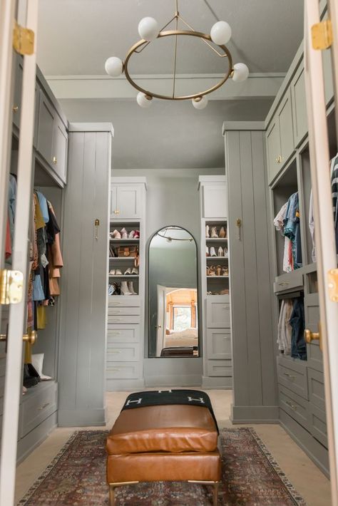 Large Closet painted bluish green colors, diy project, oversized chandelier, with leather ottoman and arched mirror. Dark Master Closet, Moody Master Closet, Moody Closet Room, Painted Master Closet, Master Closet Color Ideas, Paint Color For Closet, Painted Closet Interior, Moody Master Suite, Primary Closet Design