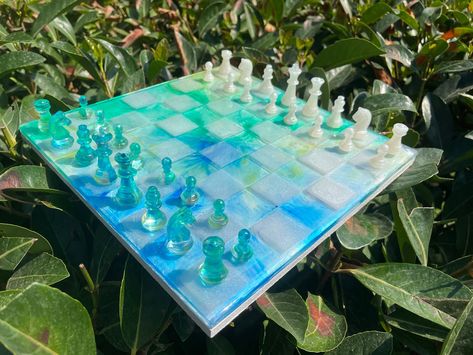 "Thank you for visiting ! Chess board made of mold and made using epoxy.And epoxy blue - white chess pieces.Chess set can be customize for your wish. Chessboard made of epoxy with epoxy handmade chess pieces. The chessboard design is completely unique. There is wooden mdf under the chessboard to keep it solid. It is attached to the chessboard. It is ideal for adults and especially children. Children get used to chess and are eager to play.🧸 🎁 The colorful chess set is chosen as an excellent gi White Chess Pieces, Resin Chess Set, Diy Resin Art, Diy Resin Crafts, Chess Pieces, Chess Set, Resin Diy, Chess Board, Resin Crafts