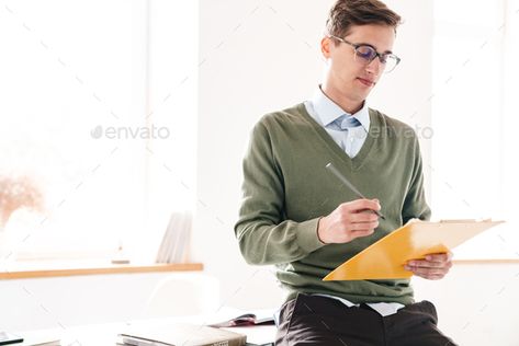 Guy student holding clipboard writing notes. by vadymvdrobot. Image of a concentrated young guy student sit on table indoor in eyeglasses holding clipboard writing notes. #AD #writing, #notes, #vadymvdrobot, #clipboard Head On Table Pose, Sleeping Guys, Study Reference, Sleeping Pose, Old Greeting Cards, Draw The Squad, Crazy Man, Anatomy Poses, Sitting Poses