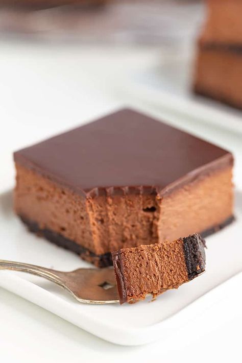 These decadent Chocolate Cheesecake Bars are an elegant dessert to make for a crowd. If you've never made cheesecake in a 9x13 pan before, you are in for a treat! This chocolate cheesecake bar recipe includes an Oreo cookie crust, a creamy, rich chocolate cheesecake layer, and topped with a chocolate ganache that's set up into a smooth, firm topping. Cheesecake Recipes 9x13 Pan, Chocolate Cheesecake Bars, Cheesecake Bar, Dessert Cheesecake, Cheesecake Layer, Dessert To Make, Oreo Cookie Crust, Cheesecake Bar Recipes, Holiday Dishes