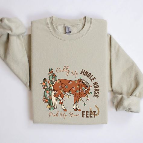 Giddy Up Jingle Horse Pick Up Your Feet Cactus Sweatshirt, Western Christmas Shirt, Cowgirl Christmas, Western Crewneck, Holiday Sweatshirt Hi, Thank you very much for choosing us For colors and designs that are not in our store, just write to us How Do I Order 1️⃣ Please review all the information provided before placing an order 2️⃣ Select the shirt type and size using the drop down menu. 3️⃣ Select the color of the shirt using the following drop down menu. 4️⃣ Please add the vinyl color (whit Western Christmas Gifts, Cactus Sweatshirt, Western Crewneck, Cowgirl Christmas, Sweatshirt Western, Navajo Print, Christmas Western, Svg Ideas, Christmas Board