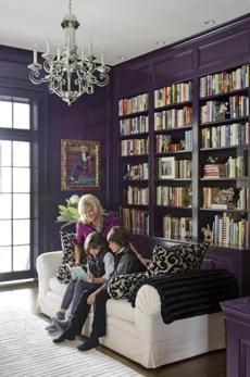 With bold colors and unusual pieces from their globe-trotting life, a couple put a distinctive stamp on their 19th-century Victorian in Manchester-by-the-Sea. Purple Wall Office, Purple Office Walls, Dark Purple Library, Purple Bookcase, Dark Purple Office, Moody Sunroom, Purple Bookshelf, Purple Office Ideas, Purple Library