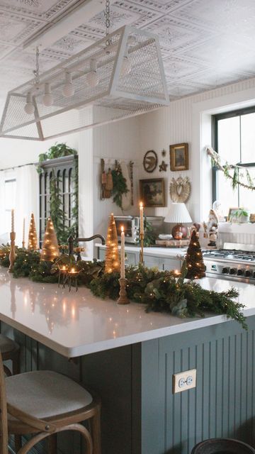 christine higgs | home decor on Instagram: "Christmas kitchen island ✨ I like to keep things cozy and clutter-free by hugging all my decor to the center of the island. I stacked the garland on top of each other and tucked the bases of the trees under the garland to save space! I really like how they looked tucked under the garland, it created a cute little forest! For twinkle lights, I LOVE @shopterrain’s party pack lights for those tricky spots where bulky battery packs just won’t do. They’ve been my go-to for years in those nooks and crannies needing some shine! All of the decor that I used here is from previous years but I linked lots of similar options on my LTK, linked in my bio! I even found deer tea light dupes!!! #ChristmasHome #VintageHome #VintageStyle #ChristmasKitchen #Holida Christmas Decor Ideas Kitchen Island, Christmas Kitchen Island, Kitchen Island Decor Ideas, Christmas Centers, Christmas Apartment, Little Forest, Kitchen Island Decor, Dream Kitchens Design, Hosting Christmas