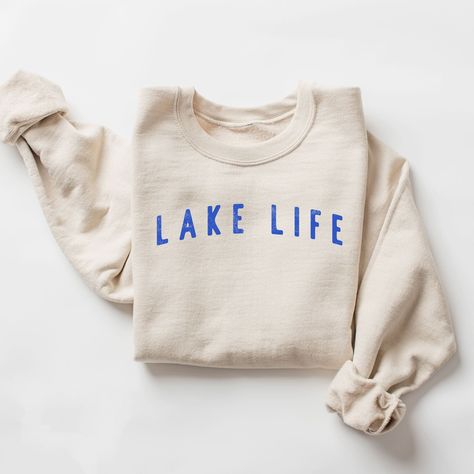 Our "Lake Life" sweatshirt is the epitome of cozy comfort, perfect for those who adore spending their leisure time by the tranquil shores of a lake. This sweatshirt is designed for both style and warmth, making it an essential addition to your summer night and cool-weather wardrobe. MATERIAL: Crafted from a blend of soft, high-quality cotton and polyester, this sweatshirt feels exceptionally comfortable against your skin. The interior is brushed for extra warmth and softness, making it perfect f Lake Outfits, Lake Clothes, Lake Outfit, Lake Gifts, Summer Sweatshirt, Boat Life, Lake Vacation, Beige Pullover, Fashionably Late