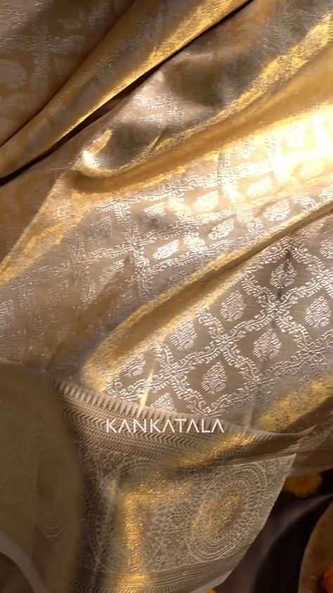 This Kanchipuram Silk Tissue Gold Saree with criss cross checks and butta delightfully radiating in the metallic hues of gold is woven to brighten up your bridal couture. Dripping elegance, the gold tissue base is embodied with gold zari tissue with silver zari criss cross checks checks and floral butta. #metallicsarees #tissuesilk #indianmetallicsbykankatala #indianmetallics #kanchipuramsaree #handmadewithlove #tissuesaree #indianheritage Gold Kanjivaram Saree, Gold Silk Saree, Kanchi Saree, Gold Saree, Golden Saree, Kanjivaram Sarees Silk, Bridal Sarees South Indian, Simple Saree Designs, Saree Tassels