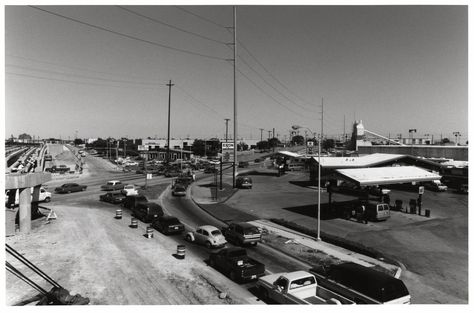 Elevated view of the intersection of Arapaho Road and North Central Expressway, looking north. The elevated portion of the expressway is not paved; it only has support beams. Motor vehicles are stopped at the intersection. On the SE corner of the intersection is an Exxon gas station, behind is a sign and car lot for OK Used Cars; then the Texas Industries Concrete facility. On the horizon are the railroad and Greenville Avenue intersections with Arapaho Road. On the NE corner is the Super ... Richardson Texas, Support Beams, Car Lot, Downtown Dallas, Texas History, Oil Company, My Childhood Memories, Dallas Fort Worth, On The Horizon