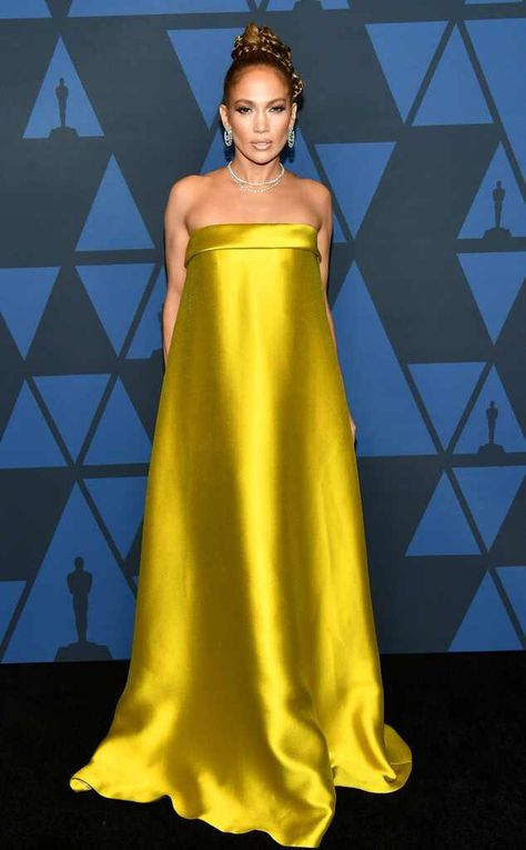 Singer and actress Jennifer Lopez strikes a pose and shows a fierce face while wearing a strapless yellow mustard gown at the 2019 Governors Awards in Los Angeles. Mustard Gown, Gown Red Carpet, J Lo Fashion, Golden Gown, Oscars 2014, Mustard Dress, Fashion Highlights, Yellow Gown, Celeb Fashion