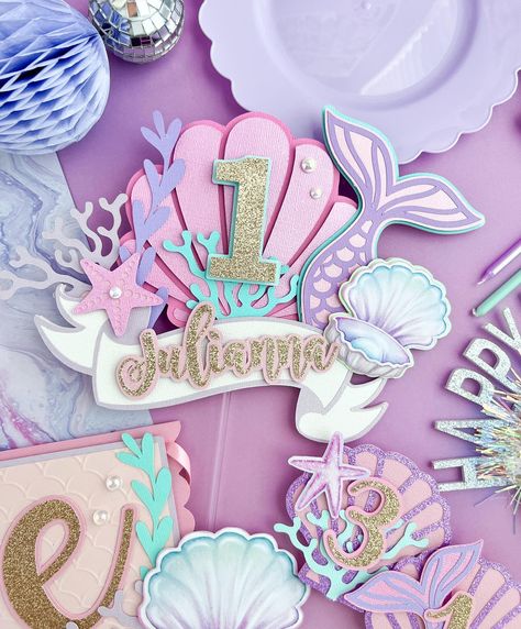 A super cute Mermaid theme decor for a little ones first birthday 🧜🏻‍♀️🫧 Using tones of pink, purple and turquoise, and iridescent….this order came out so cute! What do you think? This first birthday party package included Cake topper High chair banner Milestone cards Happy Birthday banner Name banner & Centerpieces . . . #mermaidcenterpieces #mermaidparty #milestonephotography #milestonebanner #mermaidpartydecorations #mermaidpartyideas #undertheseaparty #papeleriapersonalizada ... Mermaid Tail Topper, First Birthday Mermaid, Under The Sea Cake Topper, Sea Cake Topper, Mermaid First Birthday, Topper Mermaid, Under The Sea Cake, Ariel Birthday Party, Mermaid Birthday Decorations