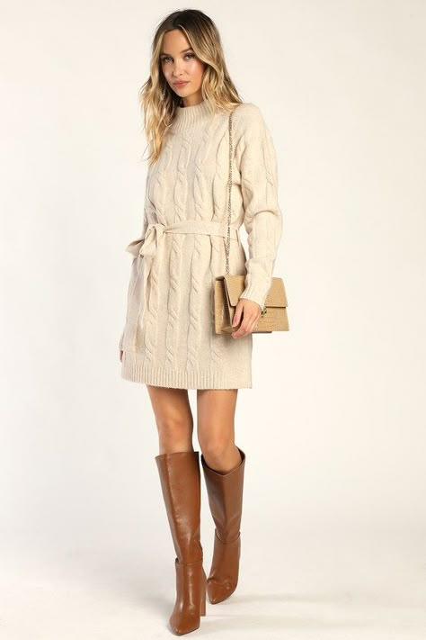 Bundling up for the season has never looked so fabulous thanks to the Lulus Warmed Up To You Cream Cable Knit Mock Neck Sweater Dress! Thick, cozy wool-blend cable knit shapes a mock neckline, long sleeves, and a relaxed bodice. The shift silhouette falls to a cute mini hem and features a tying belt that allows you to cinch the waist. Contrasting ribbed knit accents the neckline, cuffs, and hem. Fit: This garment fits true to size. Length: Mid-thigh. Size medium measures 32.5" from shoulder to h Neutral Sweater Dress, Fall Cream Dress, White Sweater Dress With Tights, Graduation Dress Winter, Cream Sweater Dress Outfit, Fall Dress Outfit With Boots, Winter Photoshoot Outfits, Cream Dress Outfit, Winter Engagement Outfits