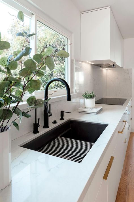 This matte black kitchen sink, which sits below the window, has a matching black faucet and hardware, while the cabinetry hardware adds a luxurious metallic touch. White Counter Black Sink, Matte Black Kitchen Sink, Kitchen Black Counter, Top Kitchen Trends, Kitchen Island With Sink, Small Modern Kitchens, Best Kitchen Sinks, Modern Kitchen Sinks, Black Kitchen Sink