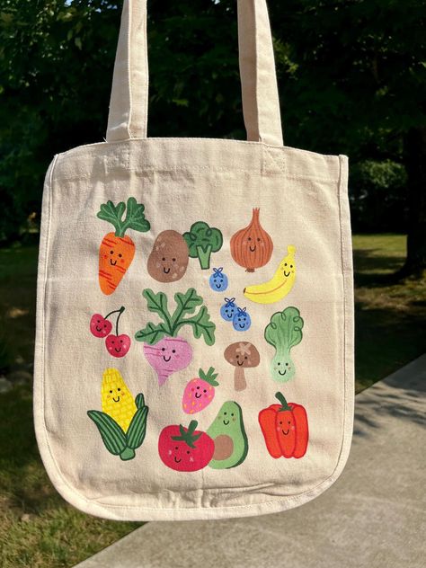 -Hand-painted canvas tote bag -fruits & veggies -Six pockets! Length: 13 3/4" Width: 13 1/4" Thickness: 6 1/2" Handle Drop Length: 10" Cute Grocery Bags, Paint Tote Bags Ideas, Tote Bag Craft Ideas, Diy Tote Bags Painting, Painting Canvas Bags Ideas, Tote Bag Painting Party, Painted Canvas Tote Bags, Tote Bag Inspo Painting, Painting Tote Bags Aesthetic