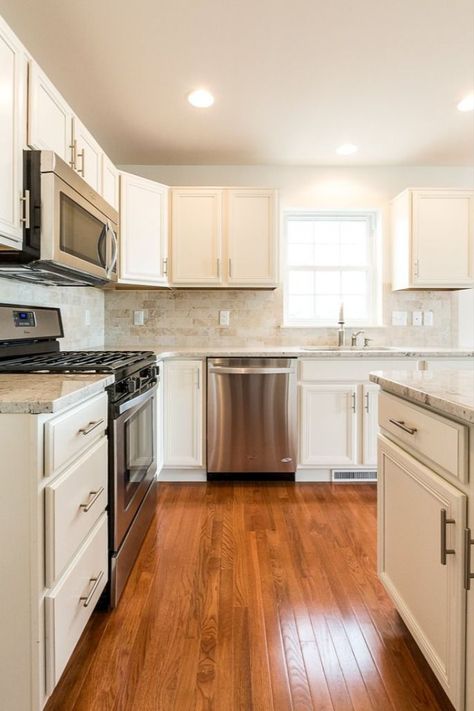 White kitchen cabinets with granite countertops and mahogany wood floors. Get kitchen design inspiration from this Berks Homes new home build! Mahogany Wood Floors, White Kitchen Cabinets With Granite, Cabinets With Granite Countertops, Kitchen Tile Inspiration, New Home Build, Classic Kitchen Design, Wood Floor Kitchen, Kitchen Floor Plans, Granite Countertop