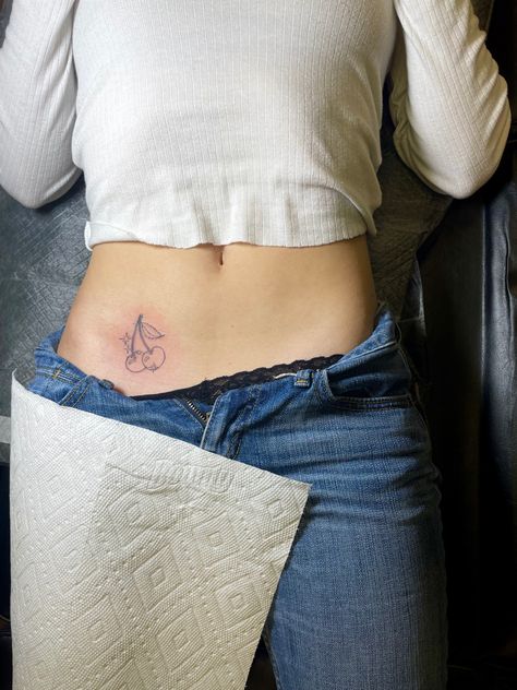 Minimalist Stomach Tattoo, Cherry Tattoo On Hip Bone, Small Cherry Tattoo On Hip, Cherry Tattoo Placement Ideas, Cherry Finger Tattoo, Cherry Hip Tattoo, Cherry Tramp Stamp, Cherry Tattoo On Bum For Women, Cherry Tattoo Small Simple